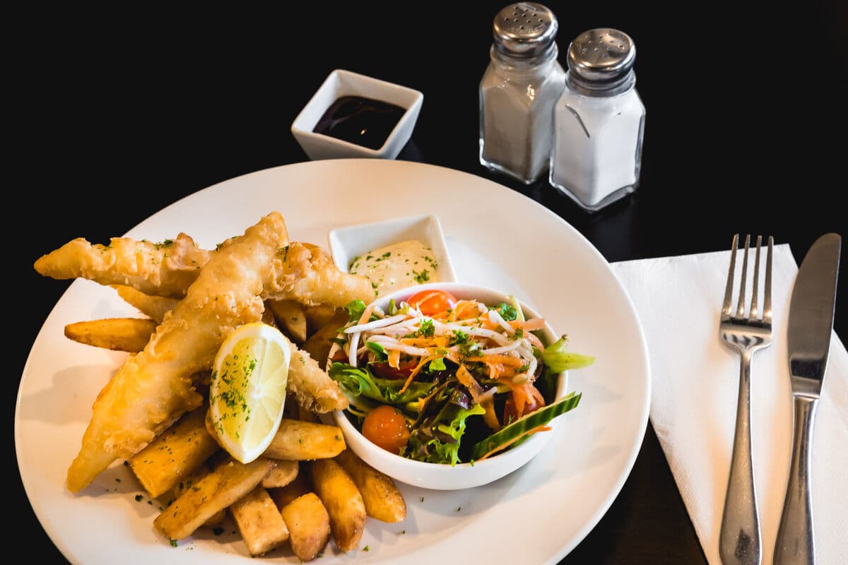 Beer battered fish and chips with tartare sauce and a lemon wedge